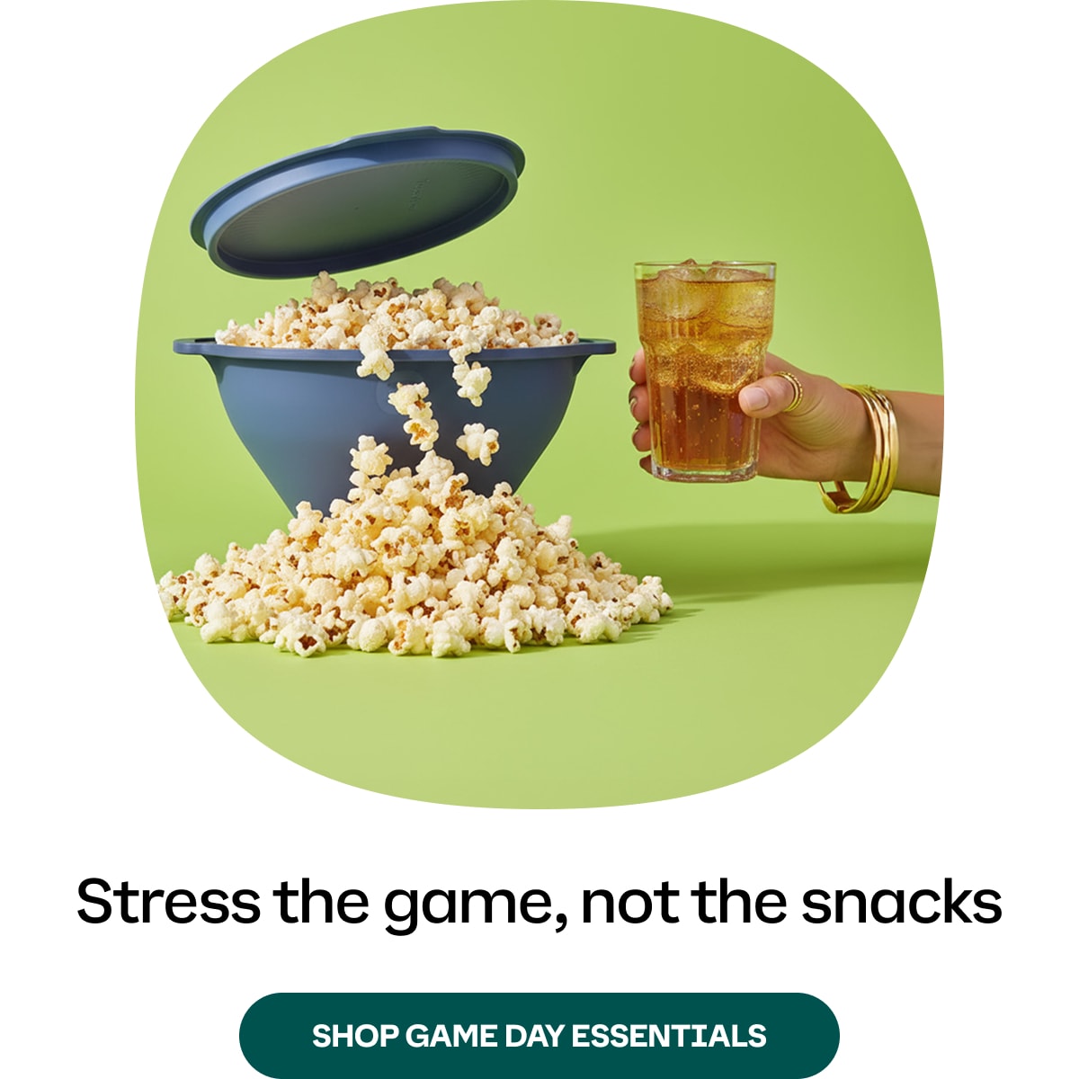 Tupperware Wow Pop Popcorn and a drink on a green background with text 'Stress the game, not the snacks' and a call to action to shop game day essentials.